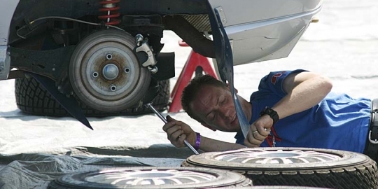 Monteur die onder een auto aan het sleutelen is